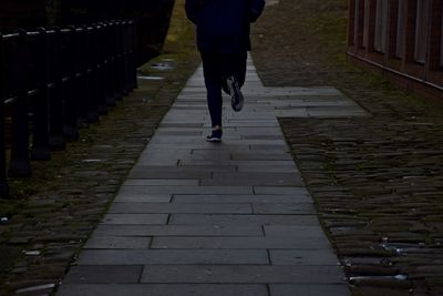 Low section of man jogging on footpath