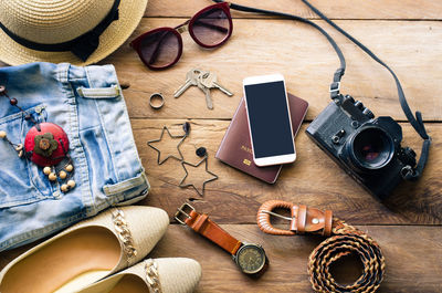 High angle view of smart phone and travel accessory on table