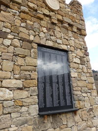 Low angle view of window on brick wall