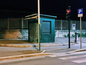 Road sign by building at night