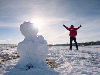 Rear view of person standing on snow covered field