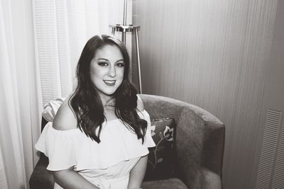 Portrait of smiling young woman sitting at home