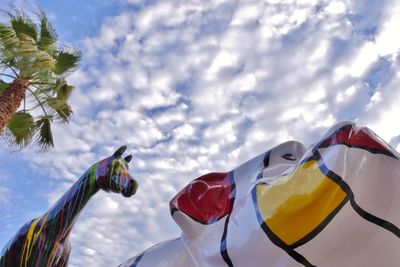 Low angle view of multi colored flags against sky