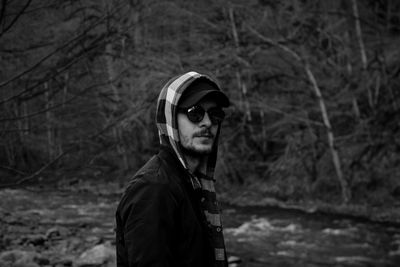 Portrait of handsome young man standing in forest