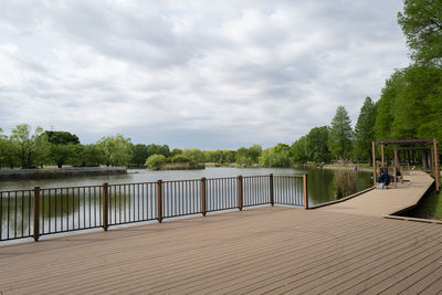 Park with an empty pond under cloudy skies.