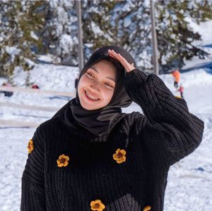 Portrait of young woman standing on snow