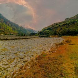 Scenic view of land and mountains against sky
