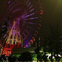 Low angle view of illuminated ferris wheel at night