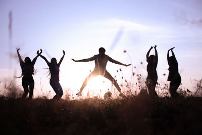 People playing soccer on field against sky