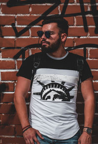 Young man looking at camera against wall