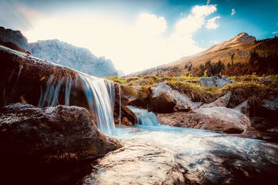 Scenic view of waterfall against sky