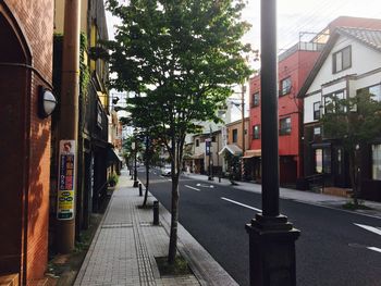 Empty road by buildings in city