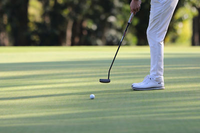 Low section of man playing golf on field