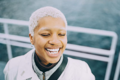 Happy young female with eyes closed standing in ship