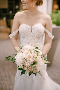 Midsection of woman holding flower bouquet