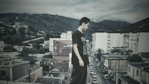 Side view of man standing on roof of building