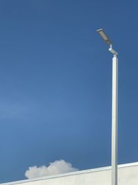 Low angle view of street light against blue sky