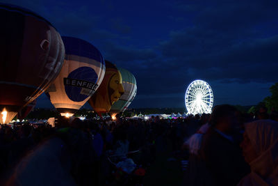 Crowd at music concert against sky at night