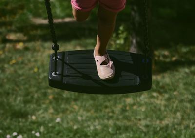 Low section of person on swing in playground