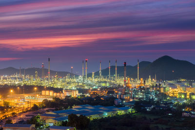 Illuminated factory against sky at night