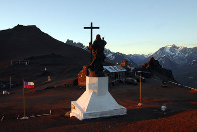 Sculpture of buddha statue on mountain against sky