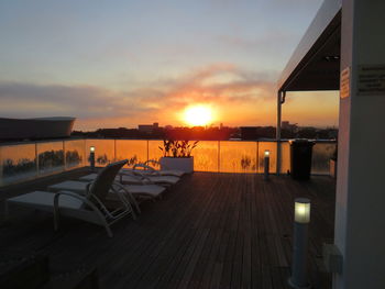 View of swimming pool by sea against sky during sunset