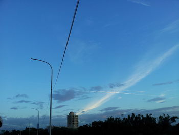 Low angle view of power lines against blue sky