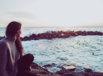 Rear view of woman looking at sea against clear sky