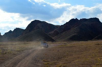 People in off-road vehicle against rocky mountains