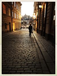 Rear view of silhouette woman walking on street