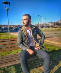 Man looking away while sitting on bench