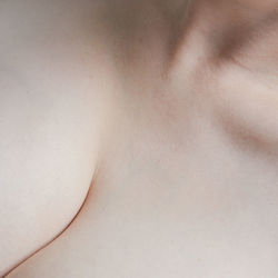 Close-up of shirtless woman against white background