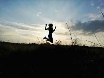 Silhouette of man jumping at sunset