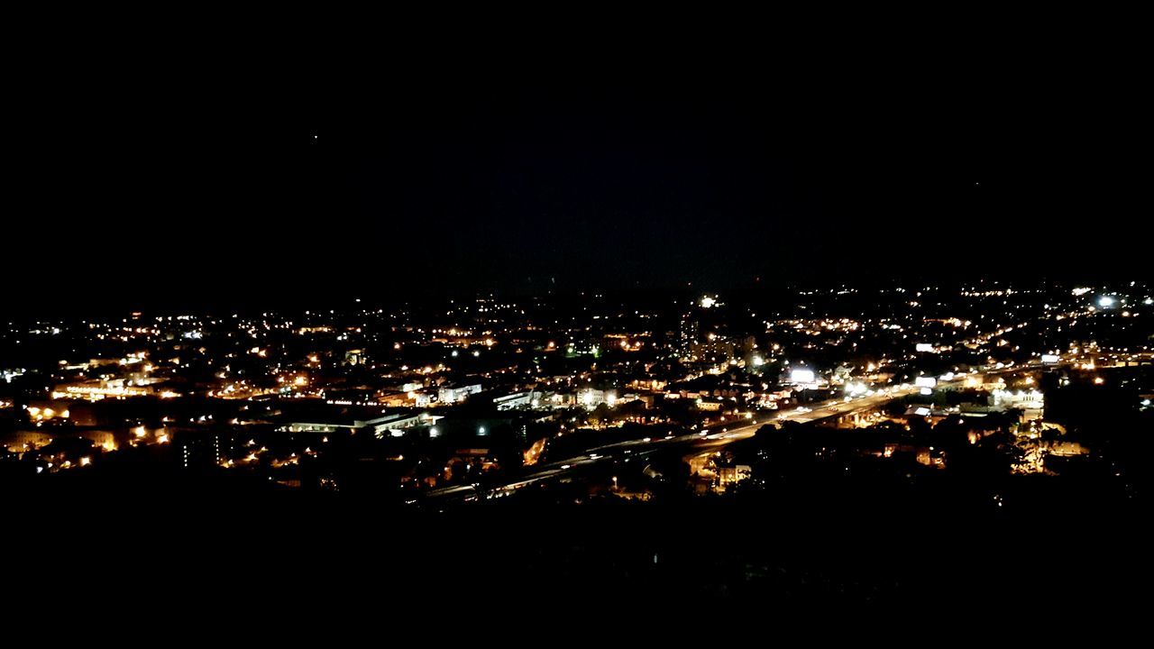 VIEW OF ILLUMINATED CITYSCAPE AT NIGHT