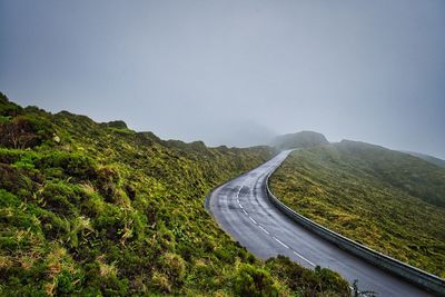 Mountain road into a foggy sky