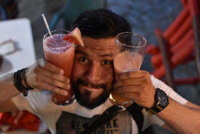 Portrait of man holding drinks