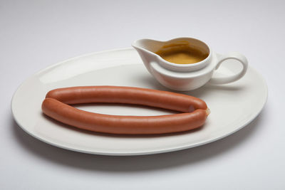 High angle view of sausage with dip served in plate on table