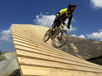 Low angle view of man riding bicycle against sky