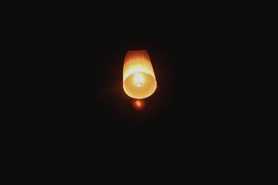 Close-up of illuminated lamp against sky at night