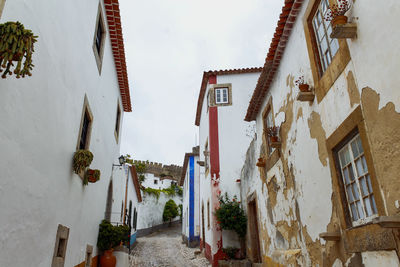 Narrow street amidst buildings in medieval city town of obidos