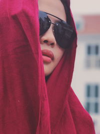 Close-up of young woman with red headscarf and sunglasses