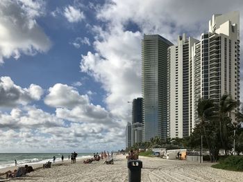 Buildings by sea against sky in city