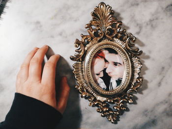 Close-up of hand by photograph on table