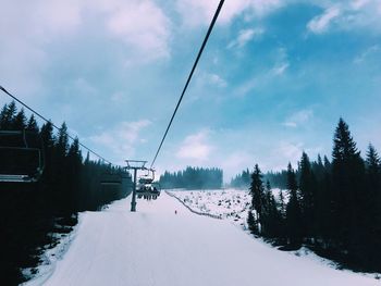 Ski lift over snow against sky