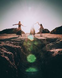 People standing on shore against sky