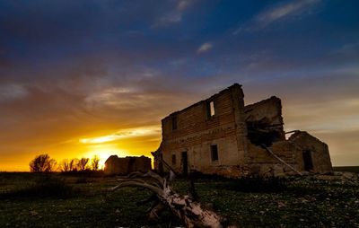 Abandoned built structure on landscape against sky