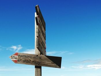 Low angle view of information sign against blue sky