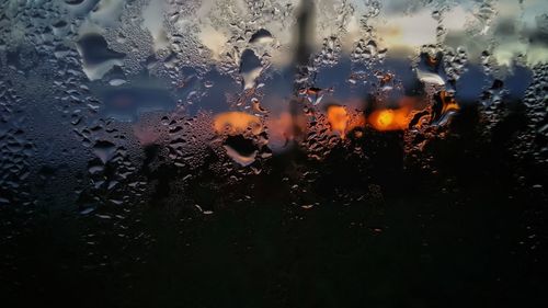 Close-up of wet glass window during rainy season