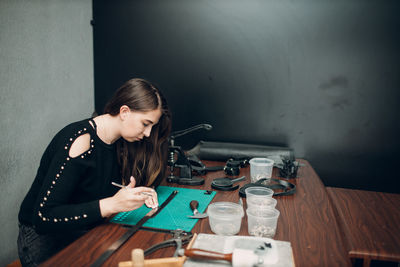 Side view of young woman doing craft at workshop