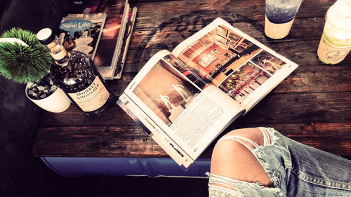 High angle view of woman reading book on table